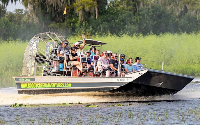 Guests on an airboat tour at Boggy Creek, Florida, enjoying the ride through wetlands.