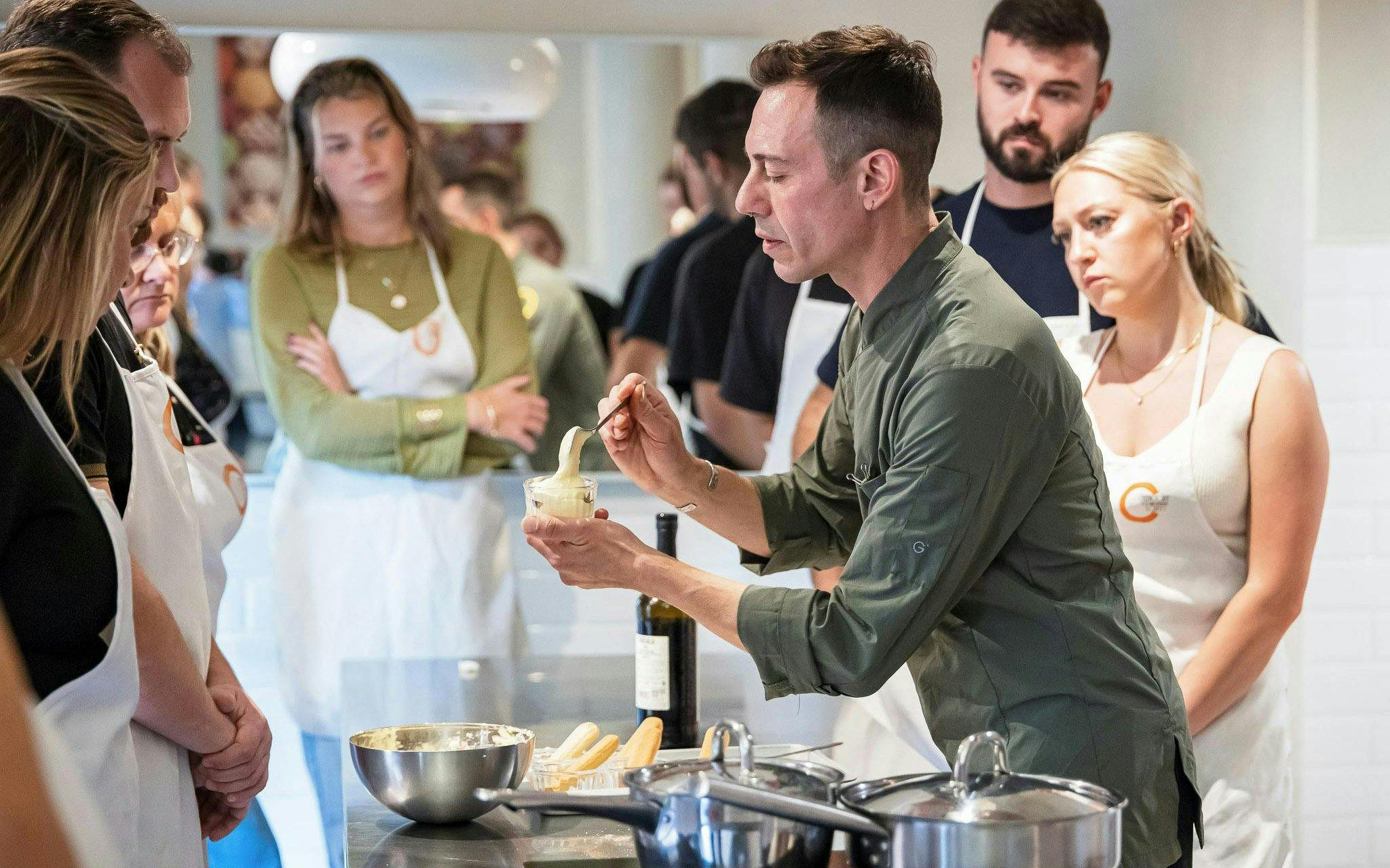 Cooking instructor demonstrating a recipe to a small group in Florence.