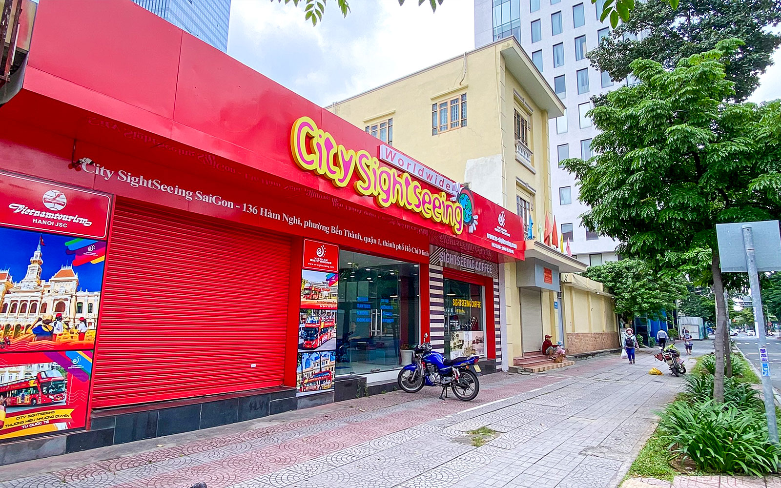 Saigon City Sightseeing tour office with vibrant red signage on a busy street.