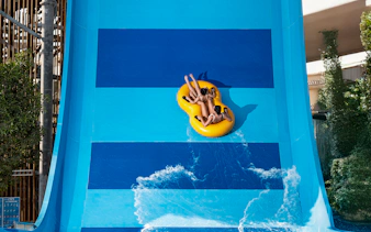 People riding Boomerango slide at Grand Hyatt waterpark, Dubai.