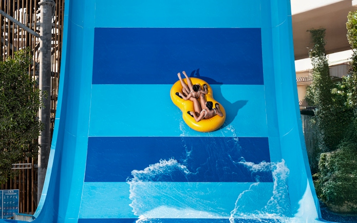 People riding Boomerango slide at Grand Hyatt waterpark, Dubai.