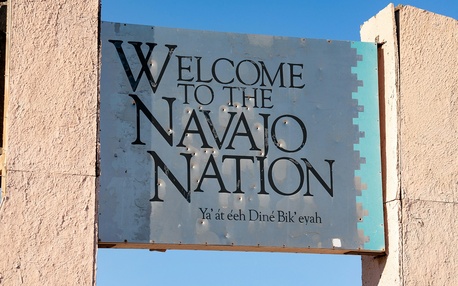 Welcome sign to the Navajo Nation with text in English and Navajo.