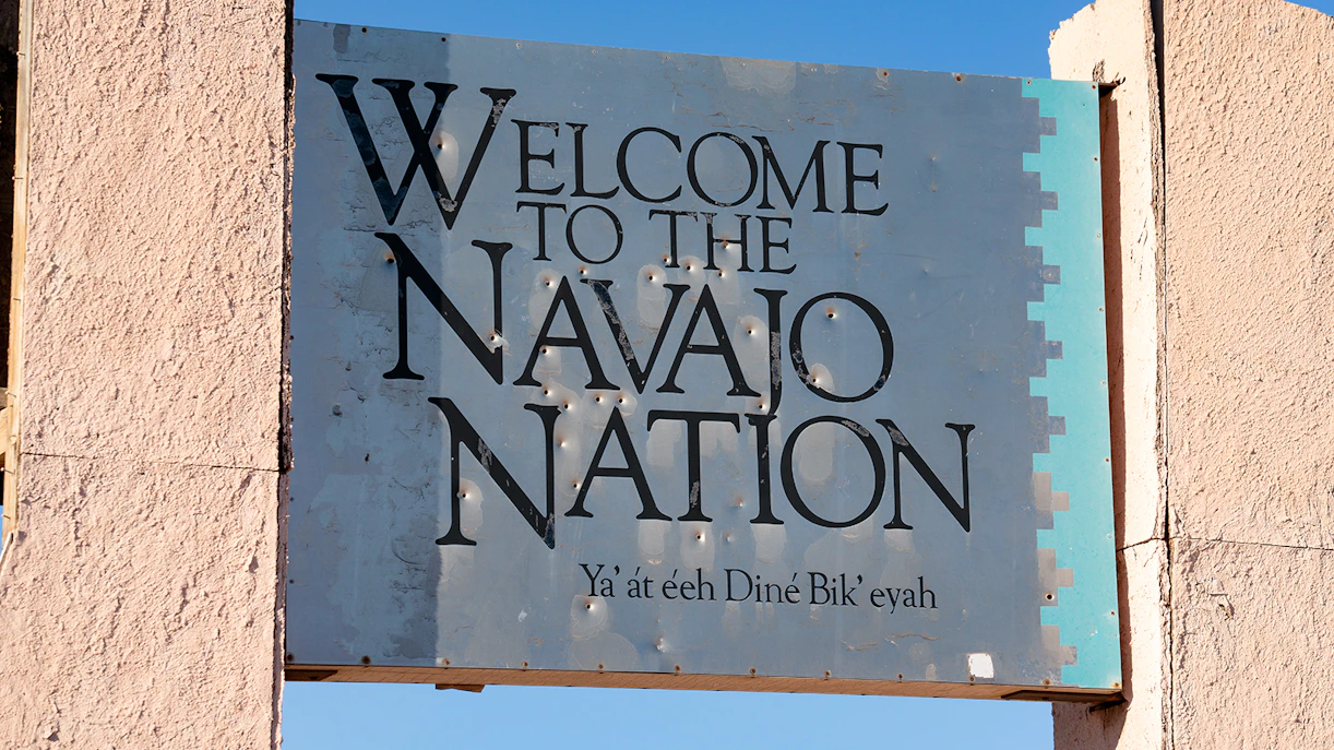 Welcome sign to the Navajo Nation with text in English and Navajo.