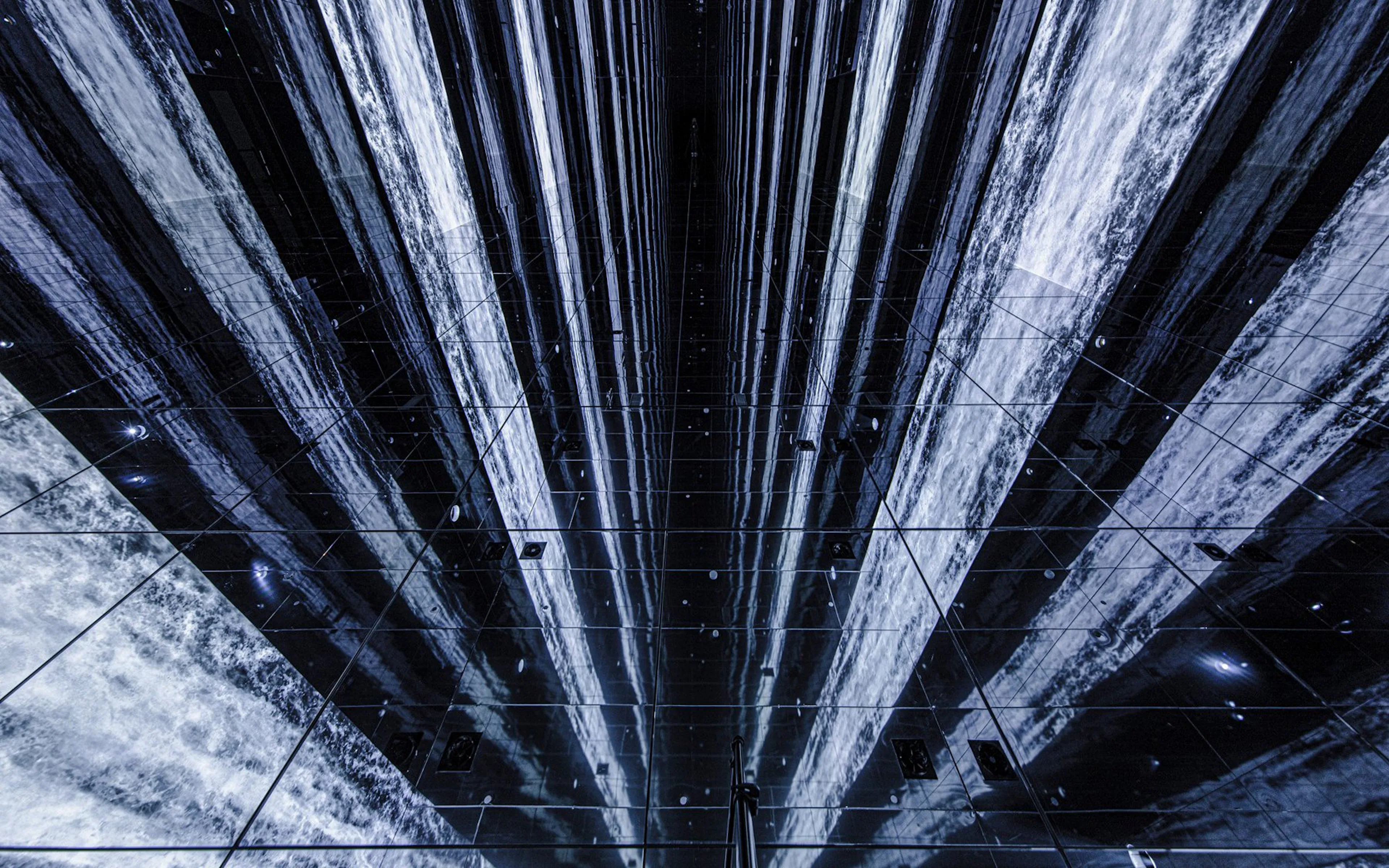 Digital waterfall installation at Arte Museum, New York, with mirrored reflections.