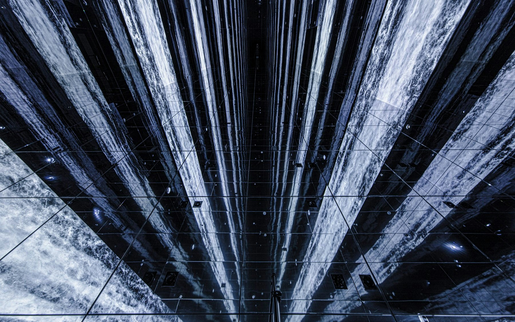 Digital waterfall installation at Arte Museum, New York, with mirrored reflections.