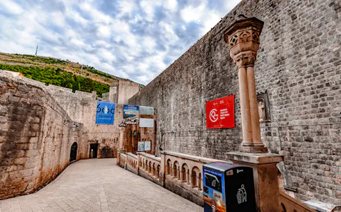 Dubrovnik city walls with banners, part of History Walk & Dubrovnik Panorama by Boat tour.