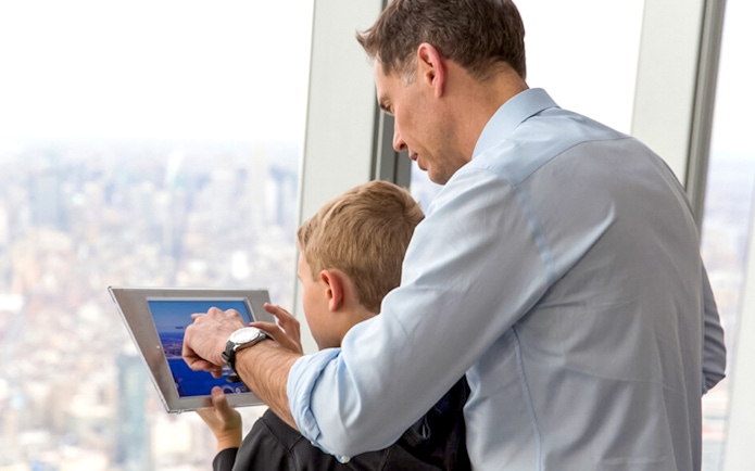 Father and son using a tablet at One World Observatory, New York City.
