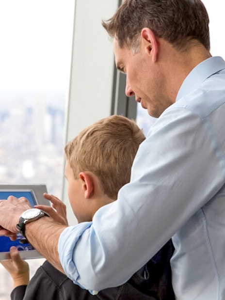 Father and son using a tablet at One World Observatory, New York City.