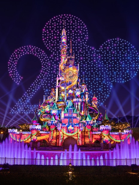 Hong Kong Disneyland castle illuminated for 20th anniversary celebration.