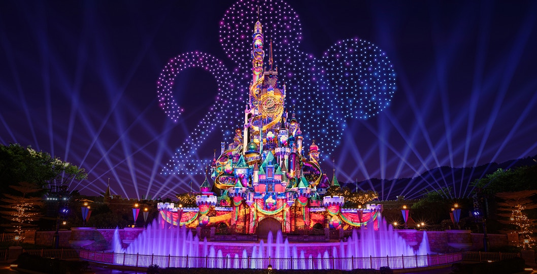 Hong Kong Disneyland castle illuminated for 20th anniversary celebration.