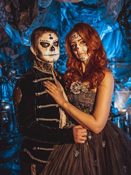 Couple in Halloween costumes with face paint at a themed event in Paris.