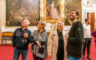 Visitors admiring artwork inside Schonbrunn Palace, Vienna.