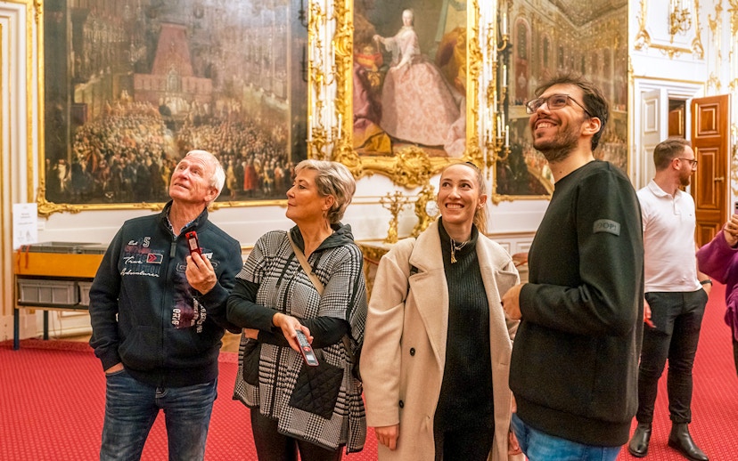 Visitors admiring artwork inside Schonbrunn Palace, Vienna.