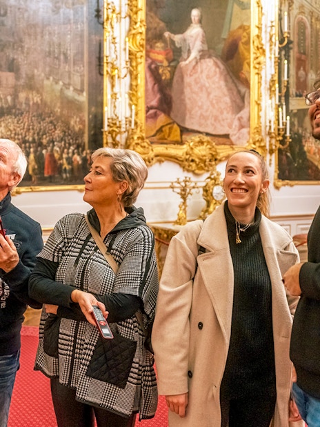 Visitors admiring artwork inside Schonbrunn Palace, Vienna.
