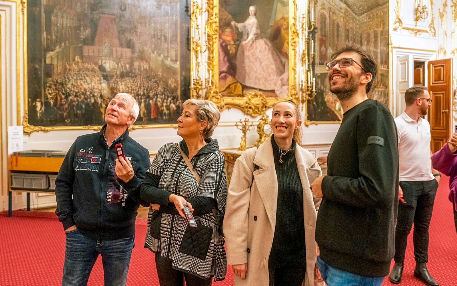 Visitors admiring artwork inside Schonbrunn Palace, Vienna.
