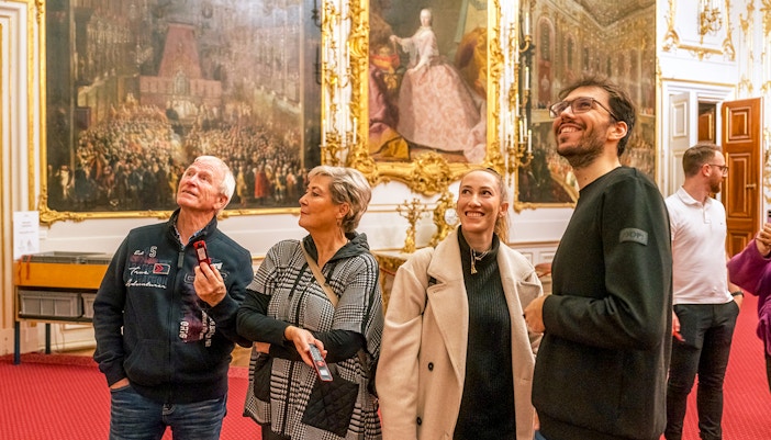 Visitors admiring artwork inside Schonbrunn Palace, Vienna.