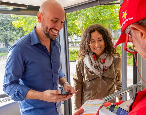 Pasajeros recibiendo entradas del conductor del bus turístico Milán.