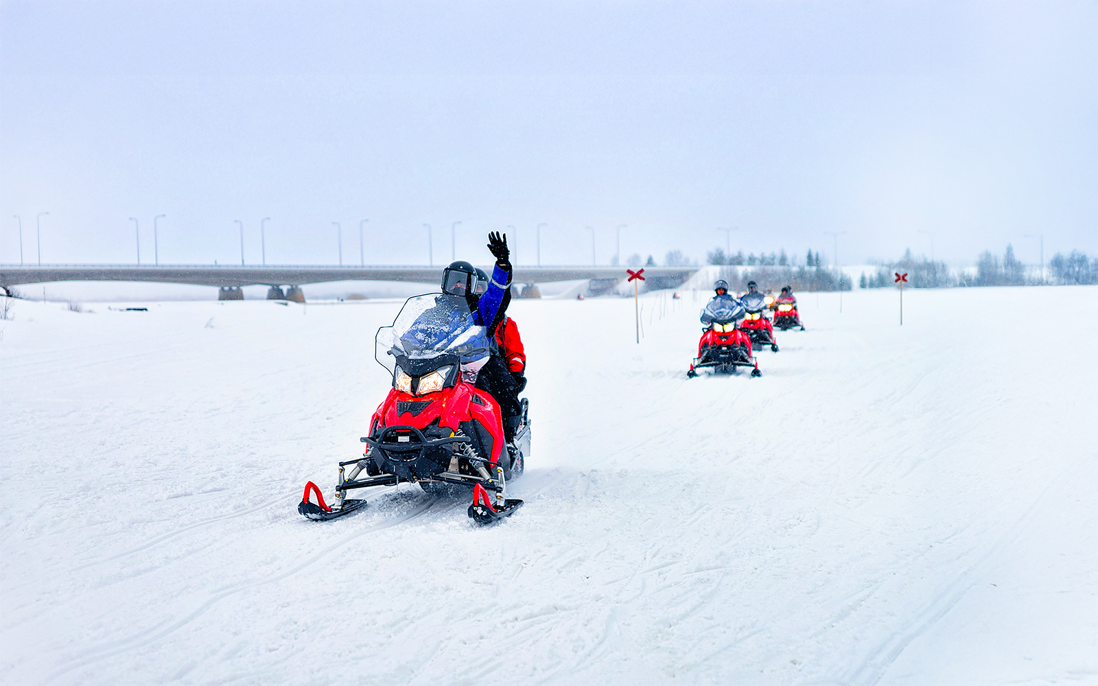 Snowmobilers on frozen lake in winter, Lapland.
