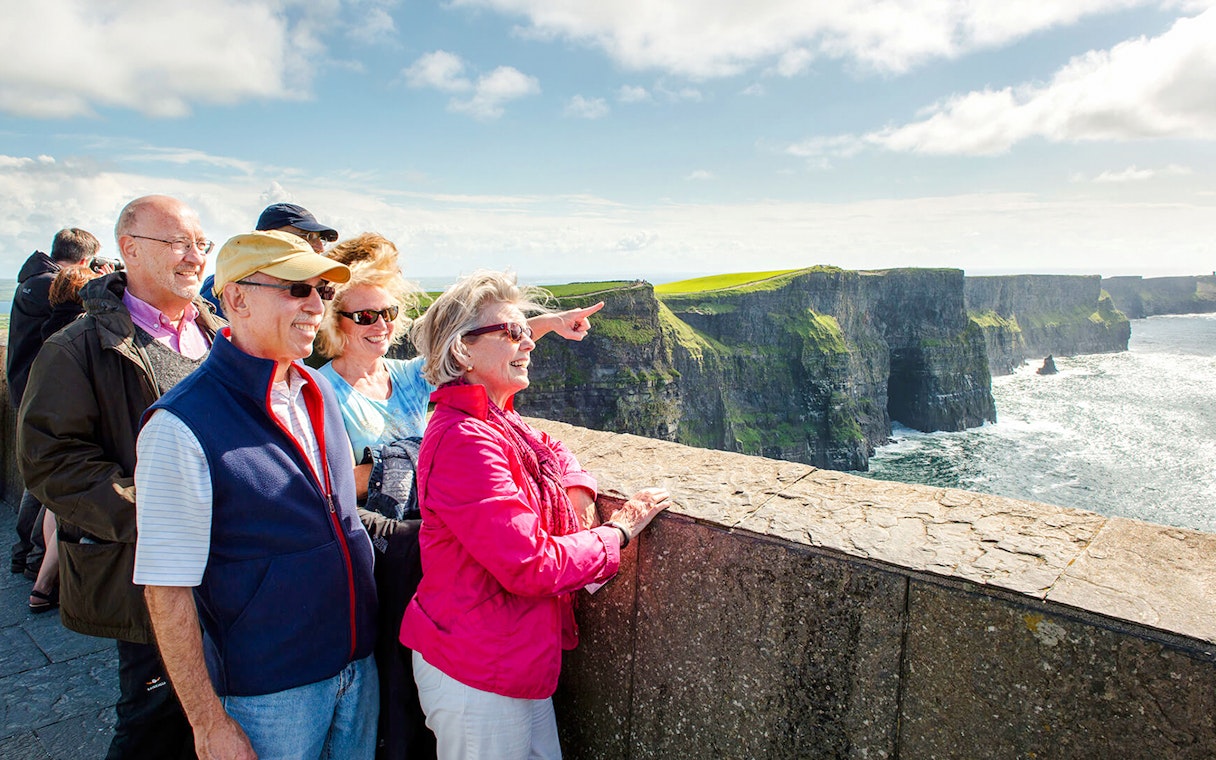 Tourists enjoying the view at Cliffs of Moher, Ireland.