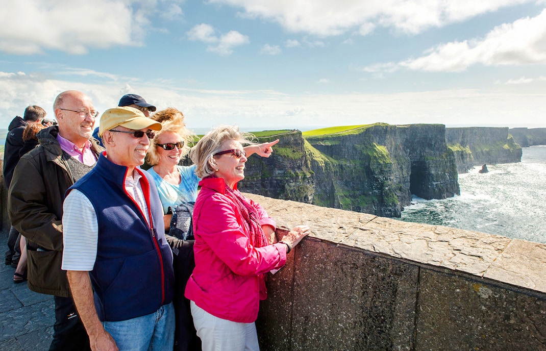 Tourists enjoying the view at Cliffs of Moher, Ireland.