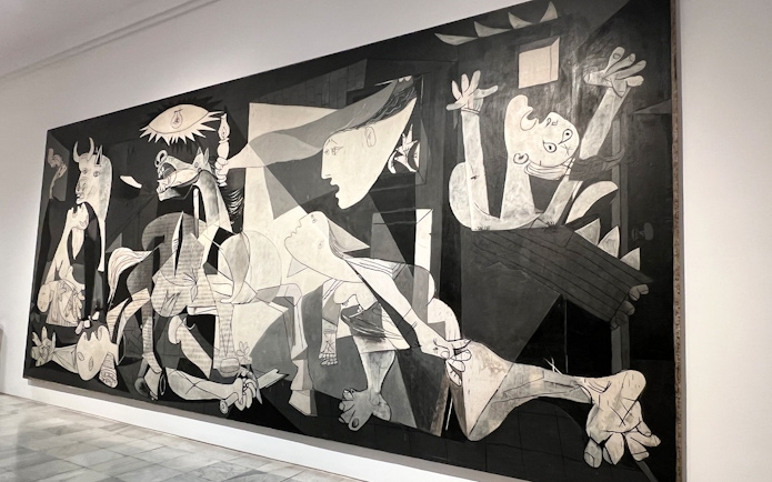 Tour guide explaining Picasso's Guernica at Prado & Reina Sofia Museum in Madrid.