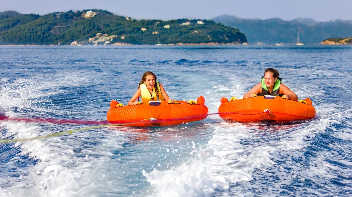 Two girls enjoying a donut ride on the water in Dubai.
