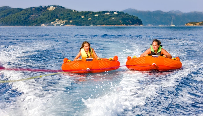 Two girls enjoying a donut ride on the water in Dubai.