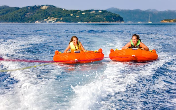 Two girls enjoying a donut ride on the water in Dubai.