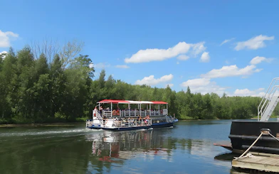 Cruise boat on Toronto Harbour with passengers enjoying the view of lush green islands.