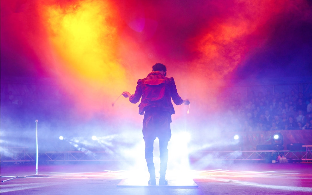 Performer on stage with vibrant lights at Aqua Circus Phuket.