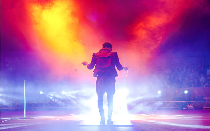 Performer on stage with vibrant lights at Aqua Circus Phuket.