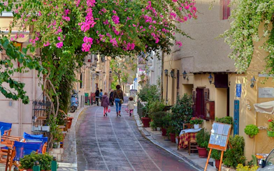 Street with traditional houses and vibrant flowers in Plaka, Athens.