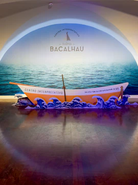 Codfish History Interpretation Centre exhibit with boat and ocean backdrop.