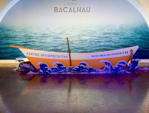 Codfish History Interpretation Centre exhibit with boat and ocean backdrop.