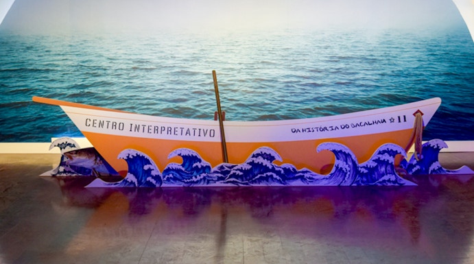 Codfish History Interpretation Centre exhibit with boat and ocean backdrop.
