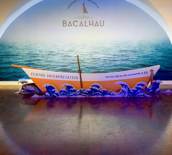 Codfish History Interpretation Centre exhibit with boat and ocean backdrop.
