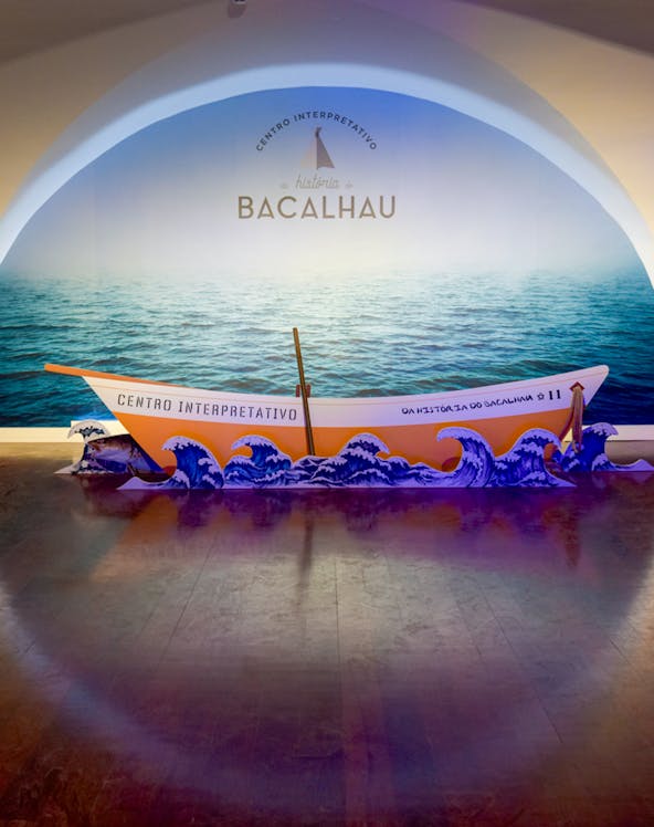 Codfish History Interpretation Centre exhibit with boat and ocean backdrop.