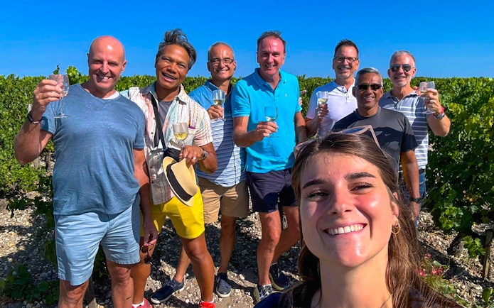 Group enjoying wine at Saint Emilion vineyard during tour.