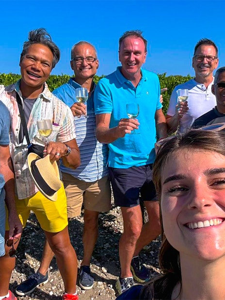 Group enjoying wine at Saint Emilion vineyard during tour.