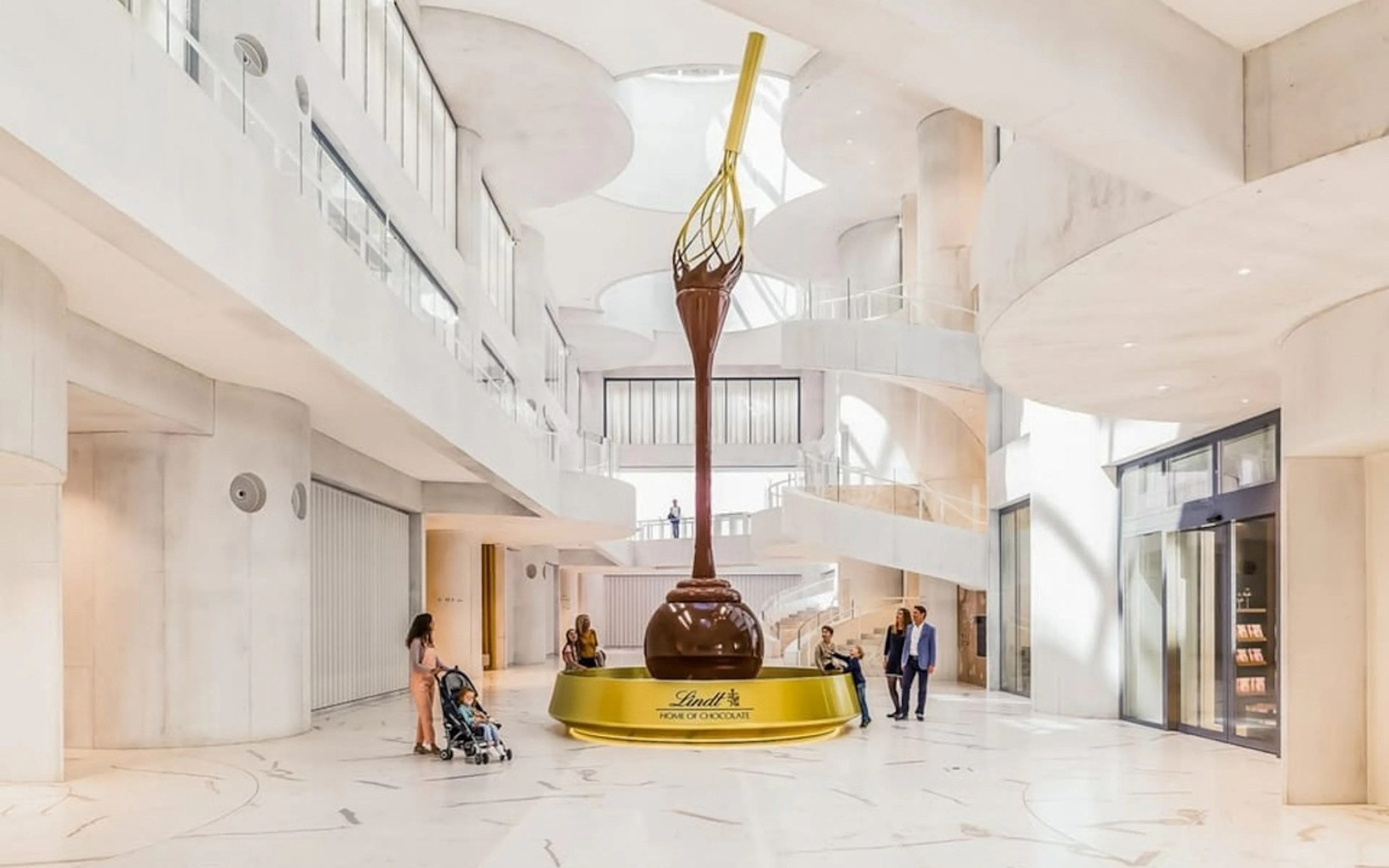 Lindt Home of Chocolate Museum interior with large chocolate fountain and visitors.