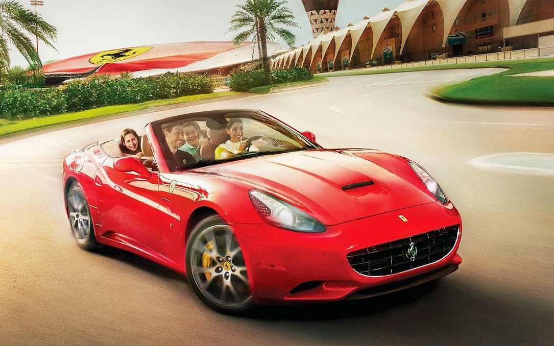 Visitors driving a red Ferrari at Ferrari World Abu Dhabi.