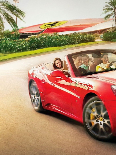 Visitors driving a red Ferrari at Ferrari World Abu Dhabi.