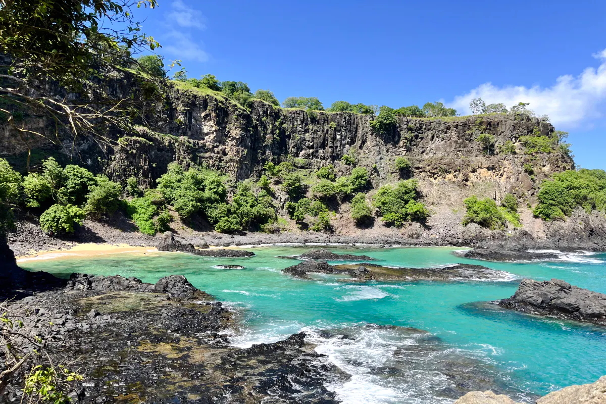 Cliffs and turquoise waters at Sancho Beach, part of the Noronha Boat Tour, Sao Paulo.