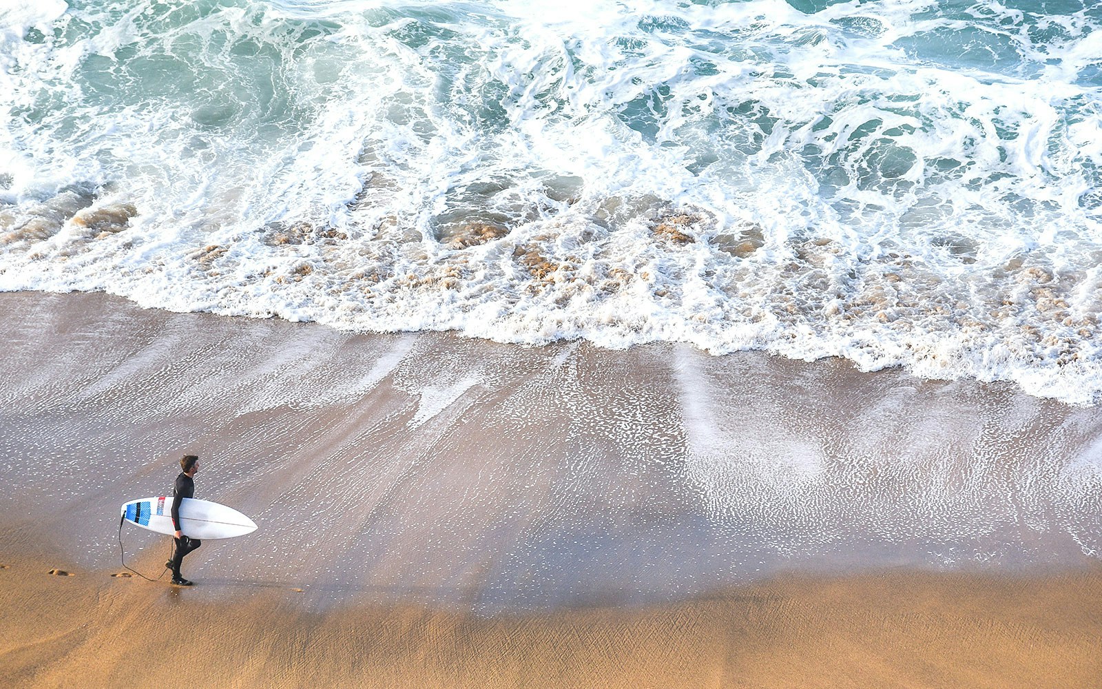 Surfers riding waves at Torquay Surf Beach, Victoria, Australia.