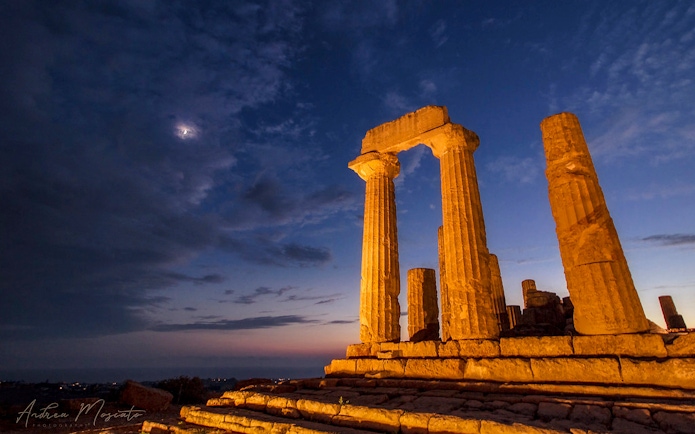 Ancient temple ruins illuminated at night in the Valley of the Temples, Italy.