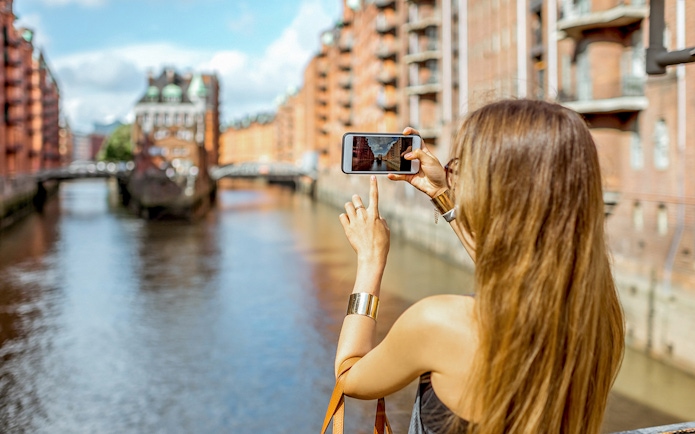Woman photographing Speicherstadt canal in Hamburg, Germany.