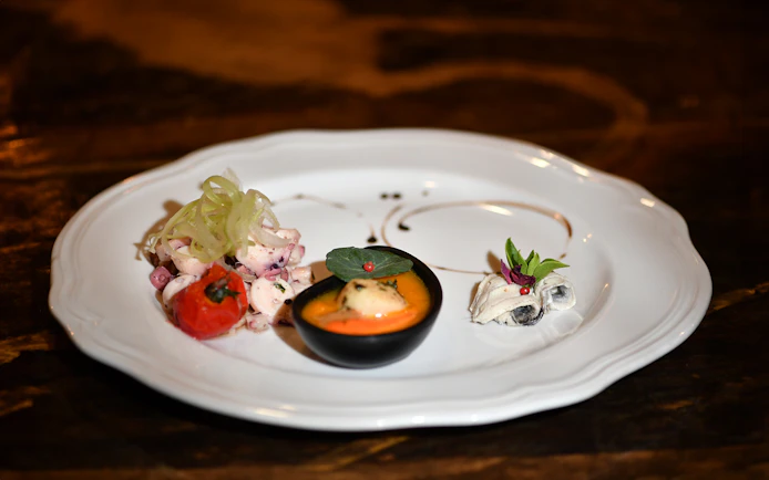 Seafood appetizer on a white plate during Galleon Dinner Cruise in Venice.