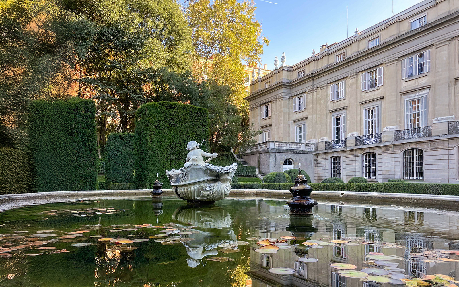 Liria Palace Gardens in Madrid with manicured hedges and historic architecture in the background.