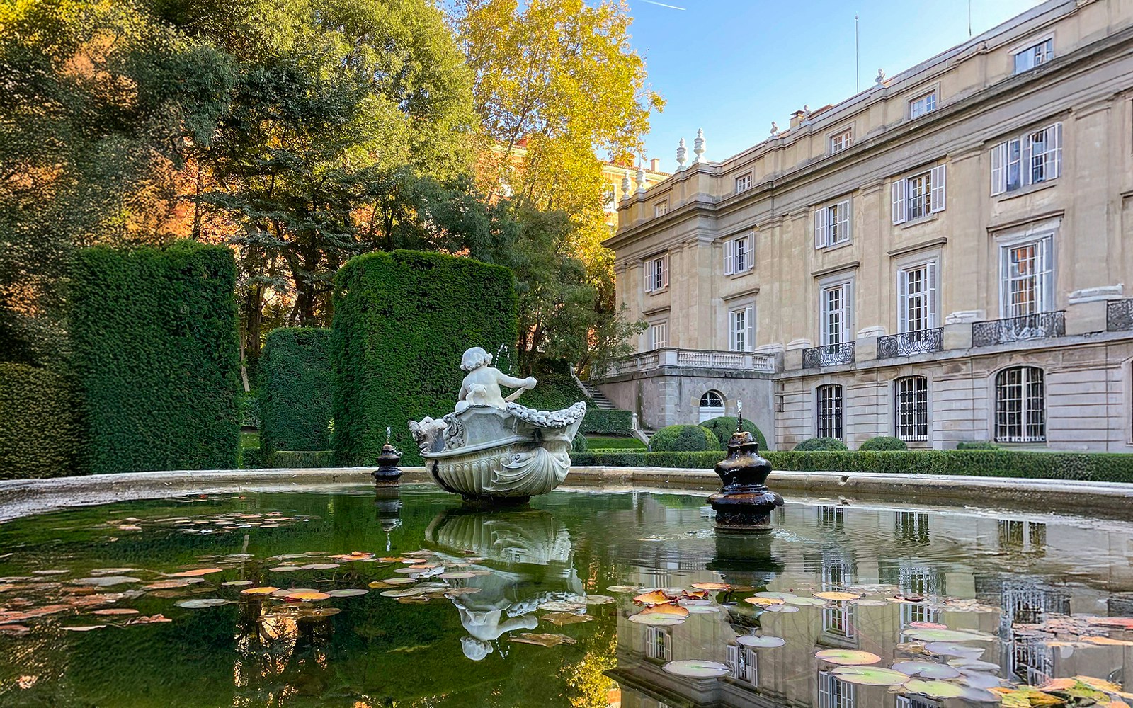 Liria Palace Gardens in Madrid with manicured hedges and historic architecture in the background.
