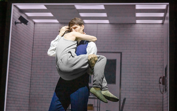 Two people embrace in a dimly lit room, evoking a scene from Stranger Things.